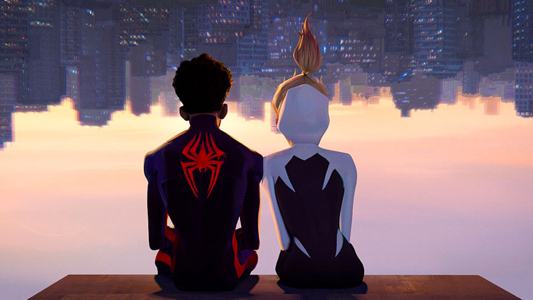 An image from SPIDER-MAN: ACROSS THE SPIDER-VERSE shows Miles Morales and Gwen Stacy sitting upside down on a ledge looking over the city.