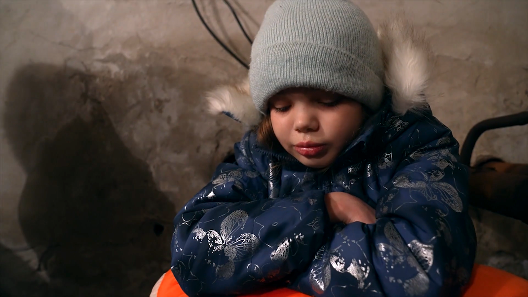 A Ukrainian girl, about five years old, sits huddled and crying in a bomb shelter in 20 DAYS IN MARIUPOL.